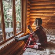 Woman with hot beverage in cozy cabin